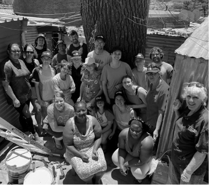 Large group of diverse volunteers posing together outdoors.